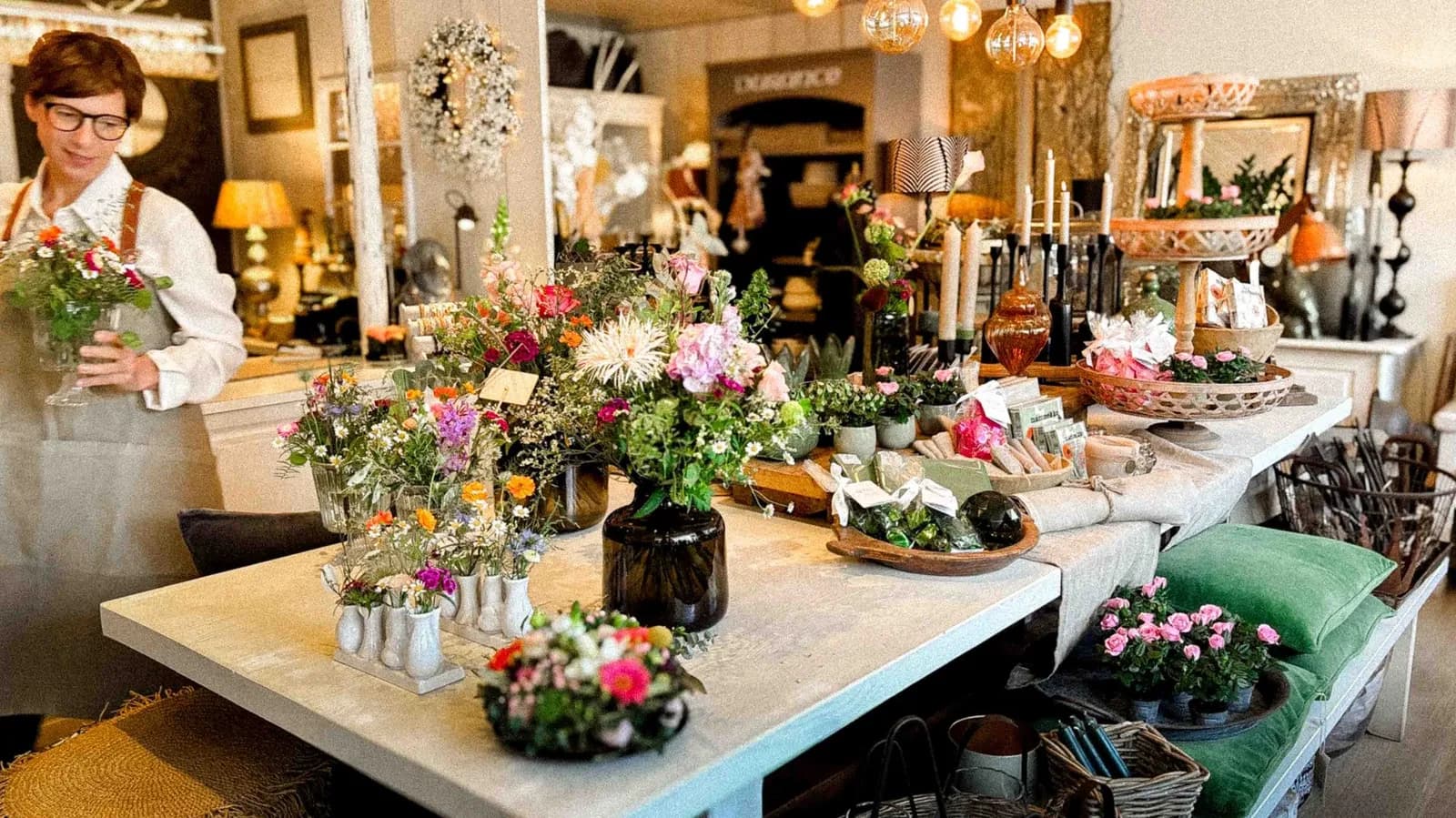 Arranging flowers at the flower table inside the Landleben store in Teufen, Appenzell